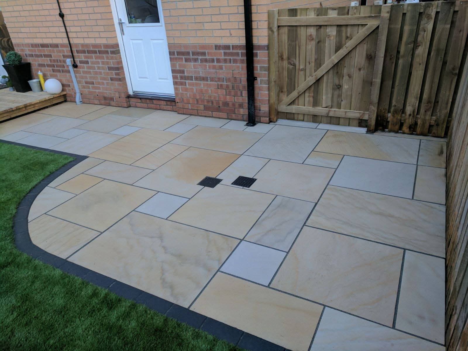 Stone patio with curved edging by Last Cut Landscaping